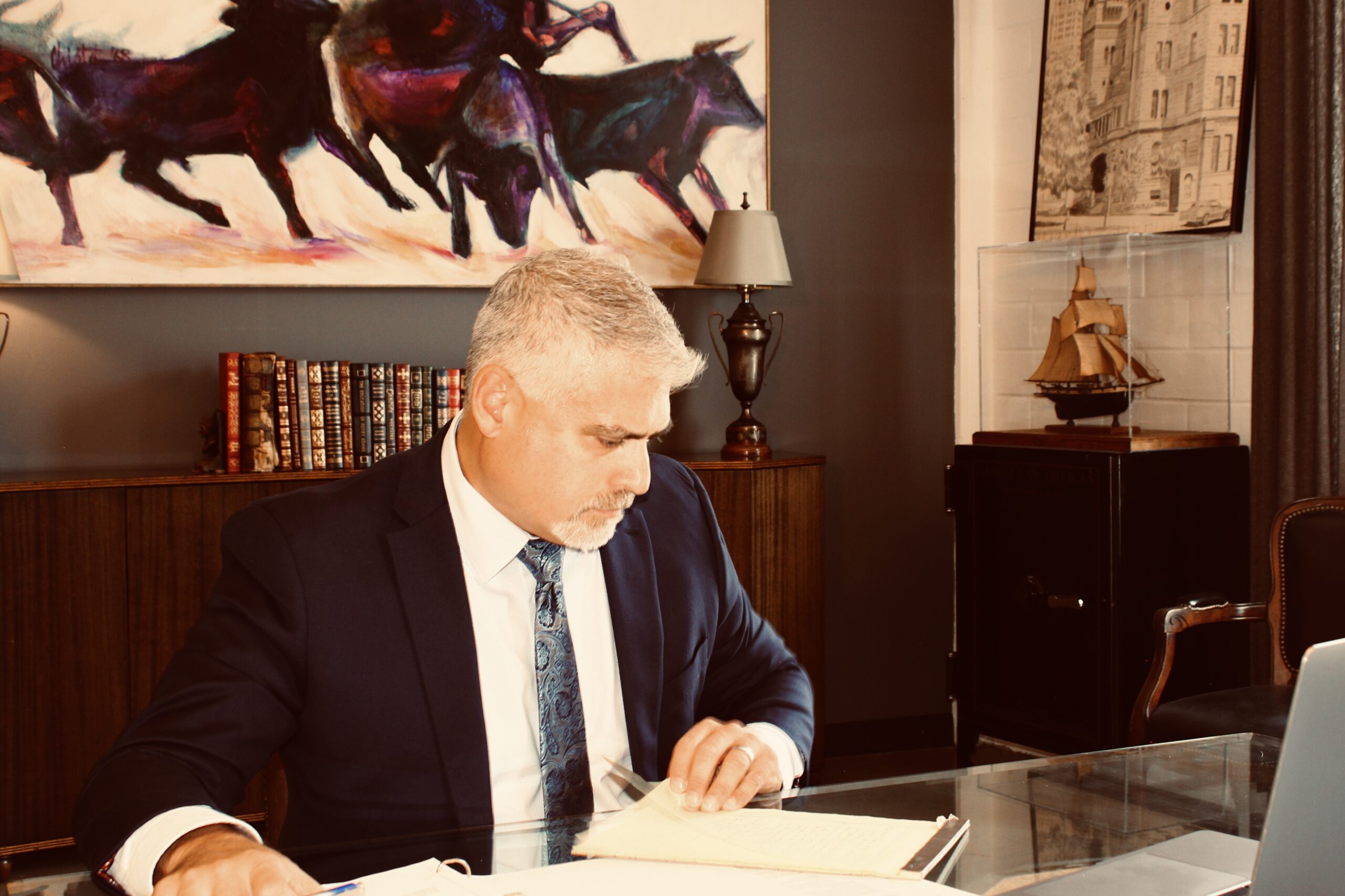 Orlando Castanon seated at a desk reviewing documents in his office